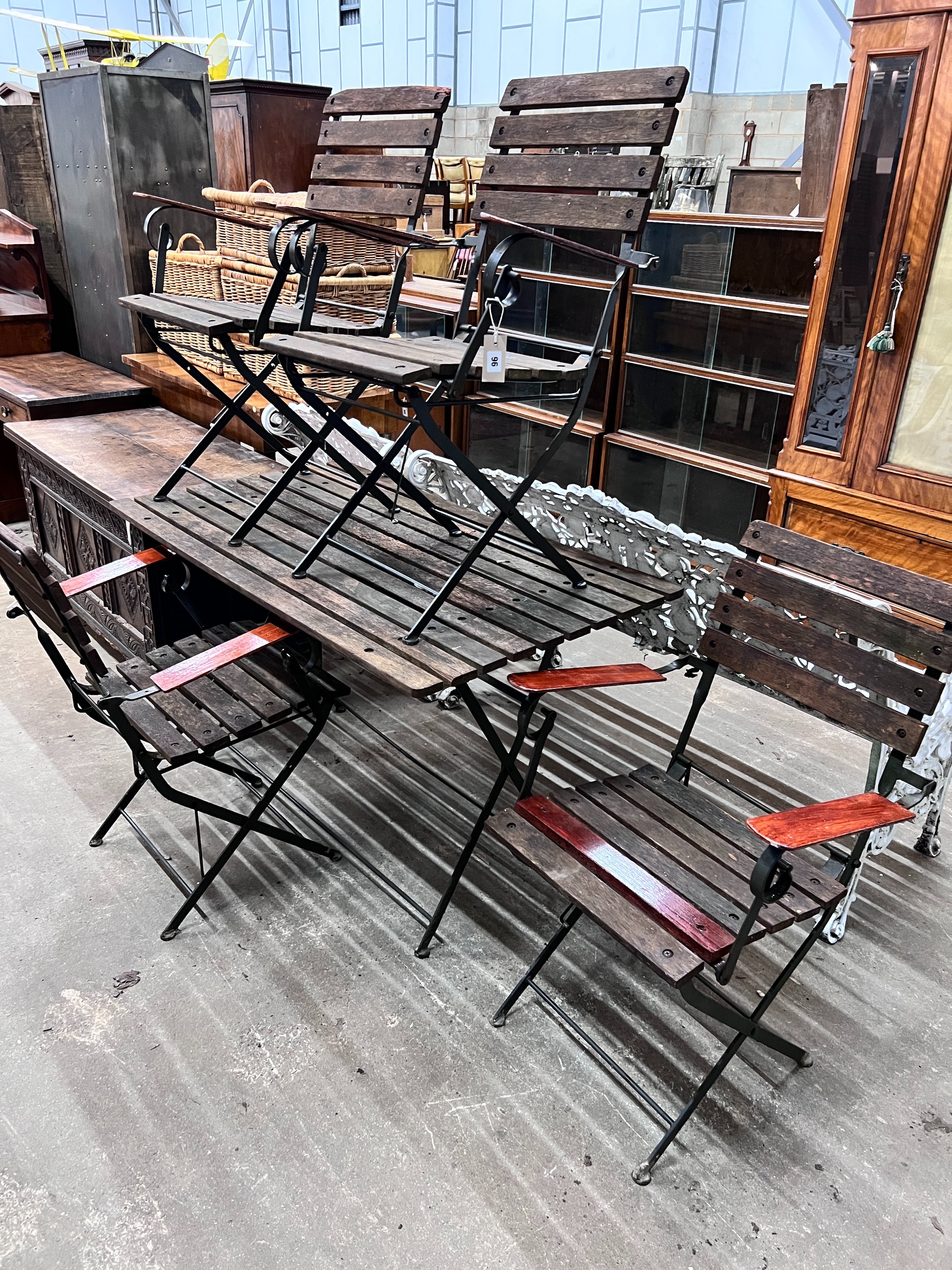 A slatted wood and wrought iron rectangular folding garden table, length 122cm, depth 68cm, height 71cm and four chairs *Please note the sale commences at 9am.